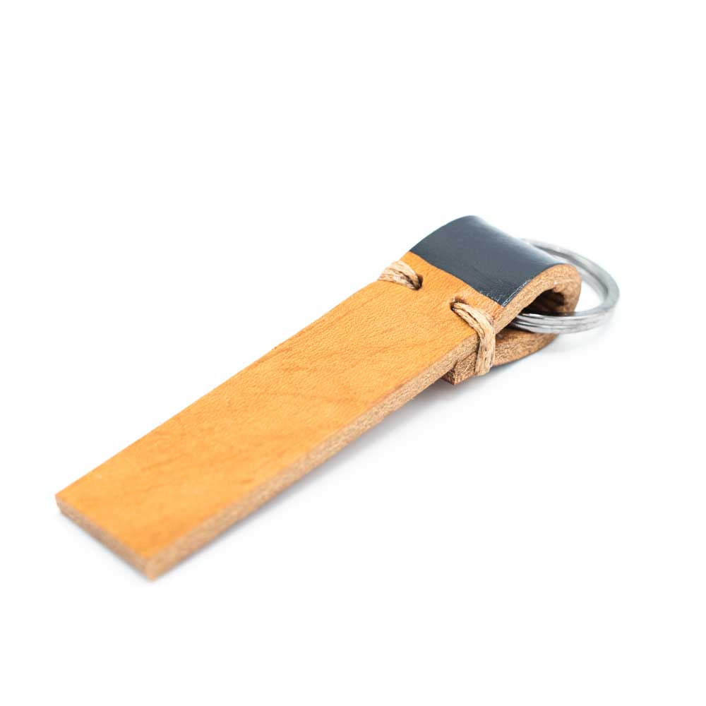 Tan leather strip keyring with anthracite colour on the part that is folded around the ring.