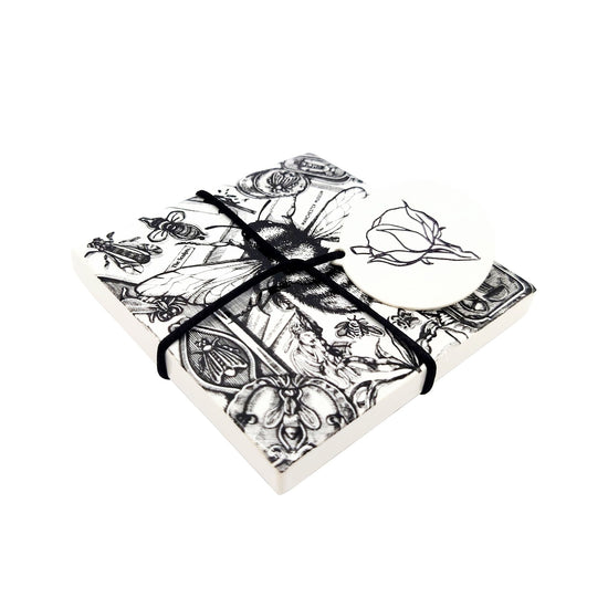 Museum bespoke style bee tile in coaster form. Seen slightly angled and with the black twine and white Sculpts tag on with a white background.