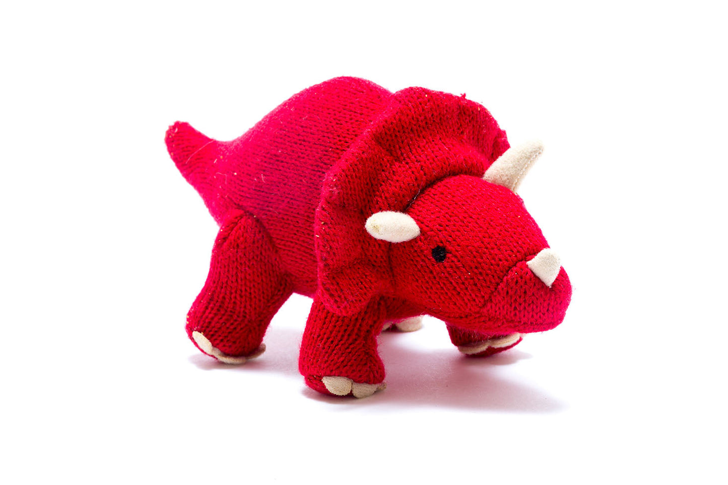 Red triceratops knitted toy against white background.