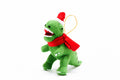 Green t-rex with a scarf and santa hat with a golden looped thread for hanging.