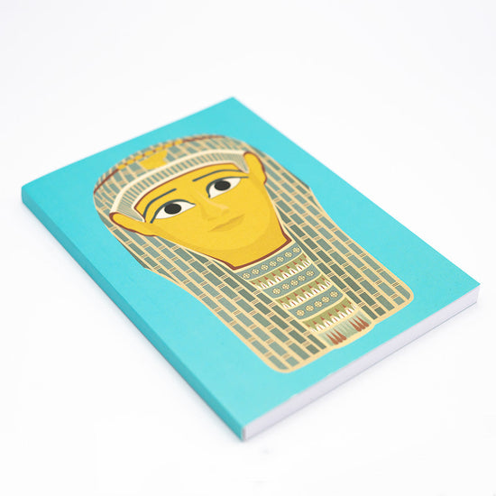 Side angled view of notebook with turquoise background and an Egyptian burial mask illustration.