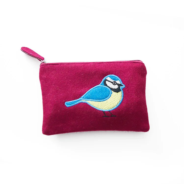 Dark purple felt purse with a blue, white and pale yellow blue tit embroidered on the front. White backdrop.