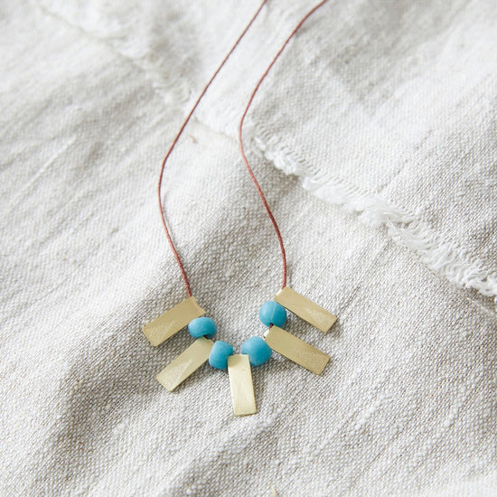 Lifestyle shot of the necklace on top of natural linen fabric.