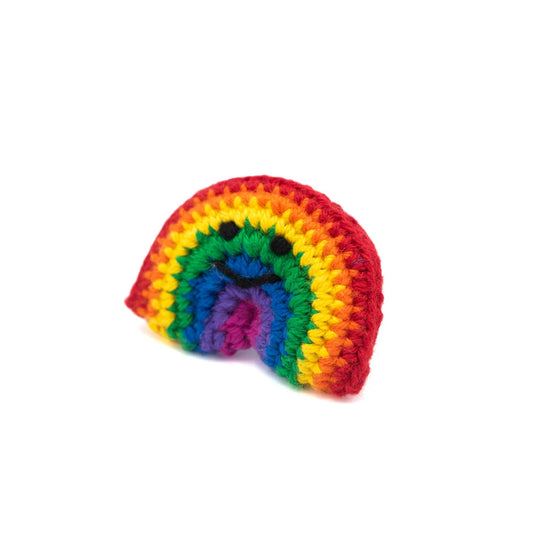 Load image into Gallery viewer, Angled view of Crochet rainbow brooch with a little smiley face in black thread.

