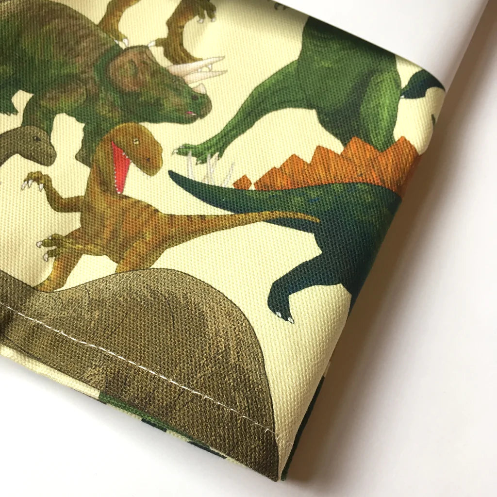 Close up of a corner of the tea towel showing dinosaur detail.