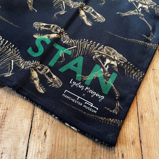 Load image into Gallery viewer, Close up of a corner of the tea towel showing the combined museum Stan and Lydia Meiying branding.
