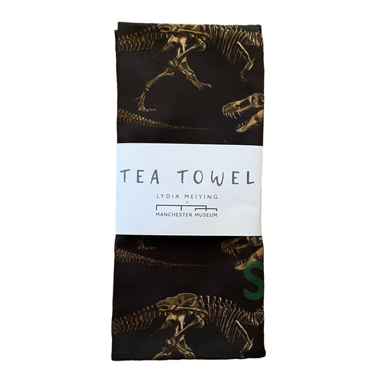The stan tea towel folded and with the white paper belly band as it appears when packaged.