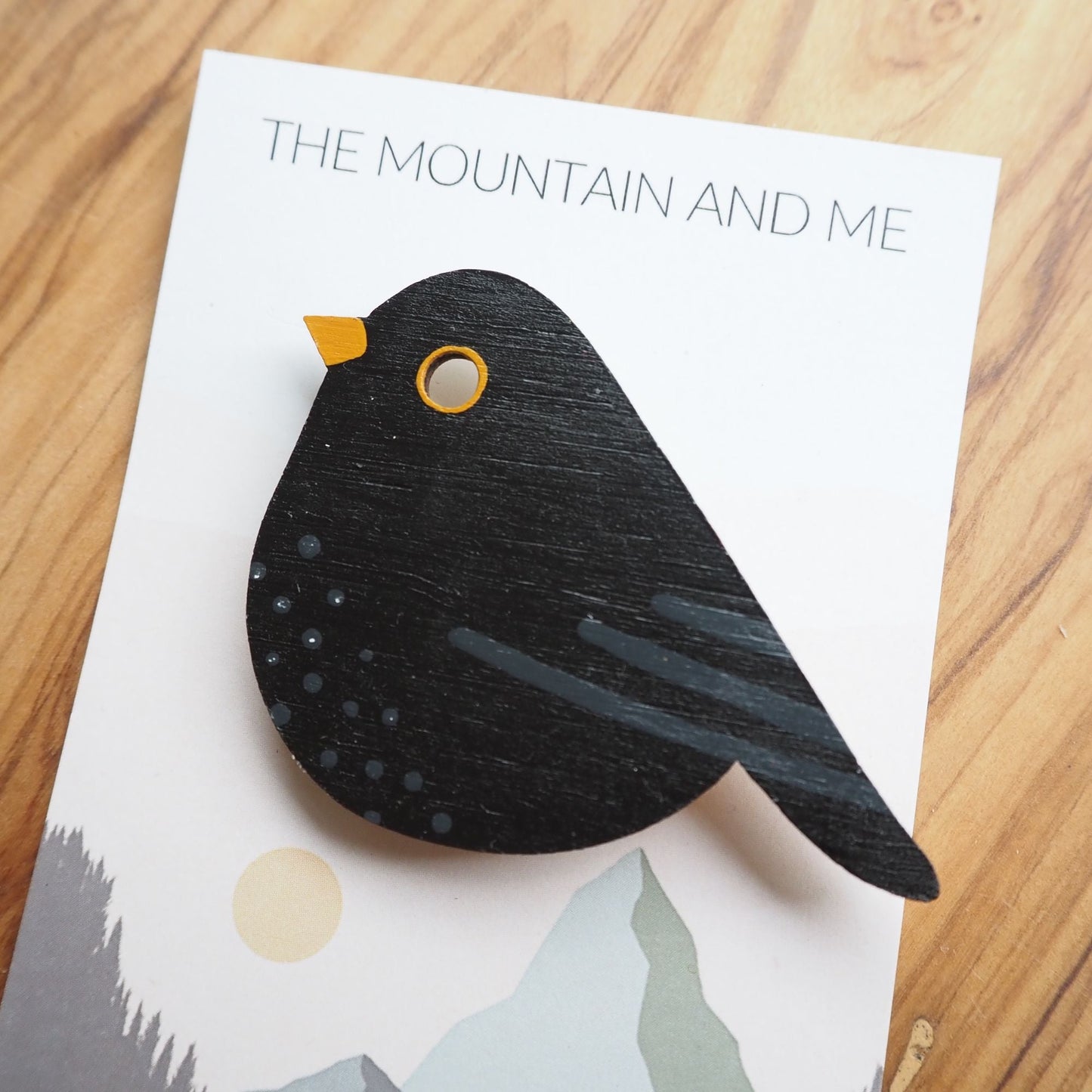 Painted blackbird brooch on the Mountain and Me branded backing card.
