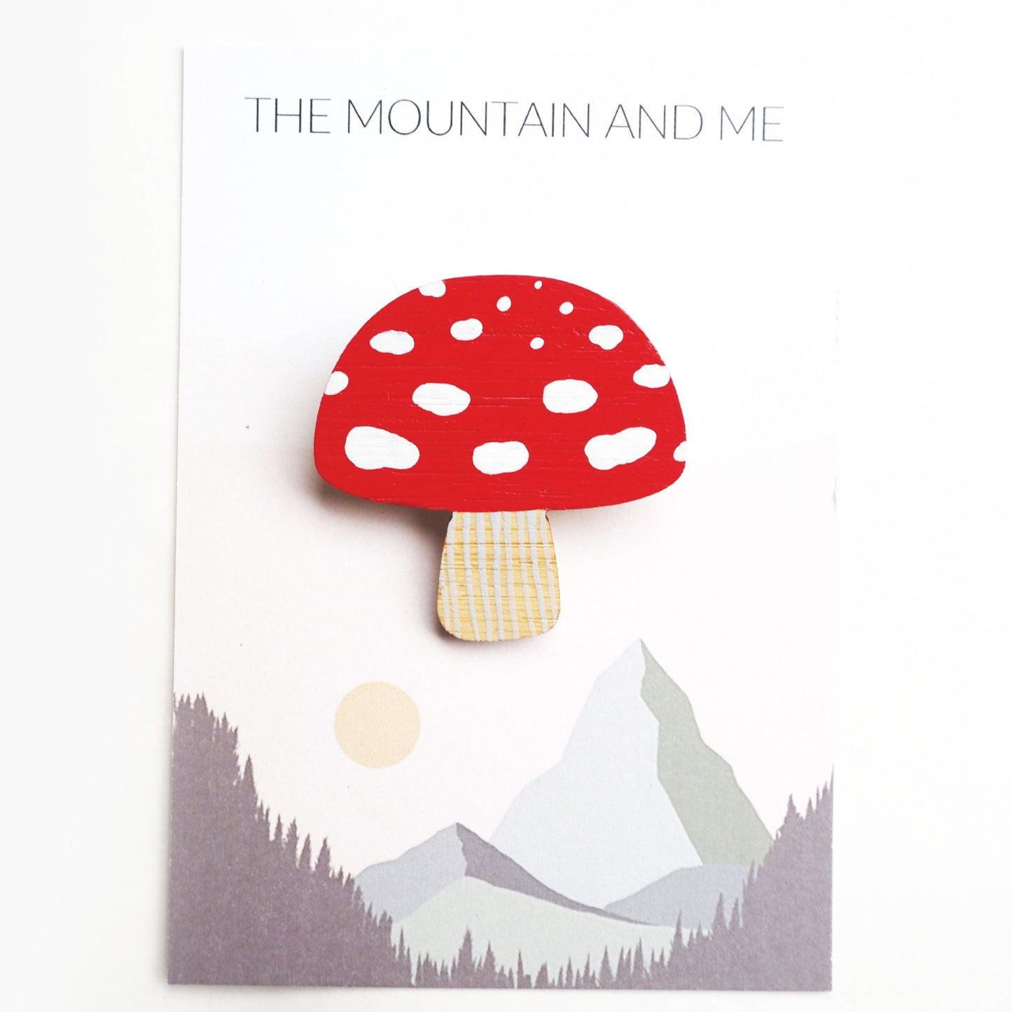 Toadstool brooch on the mountain and Me branded backing card and white backdrop.