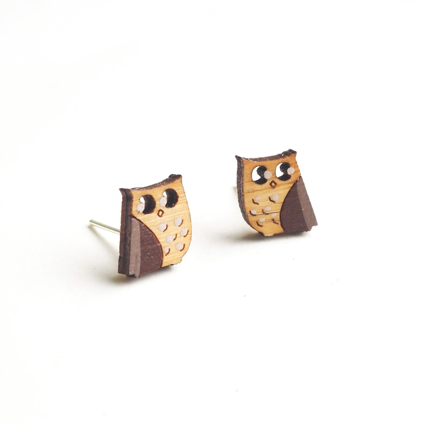 The owl earrings side by side against a white background.