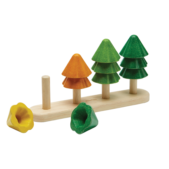 The board of the sort and count tree with the first tree disassembled on the white surface in front of it. The second tree is orange while the third tree is light green and the final tree is dark green.