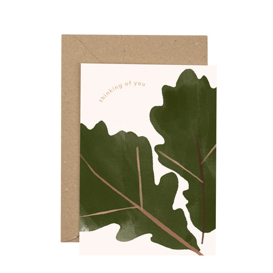 Two large oak leaves on a pale white background with the text, thinking of you.